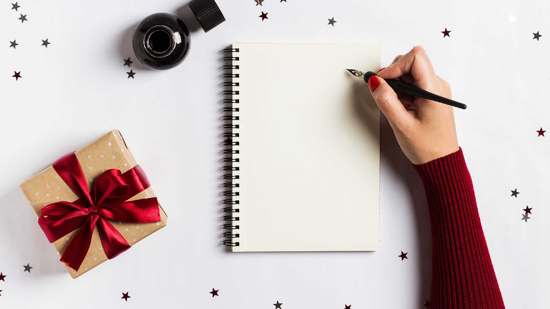 Libreta con decoración a su alrededor de estrellas y regalos